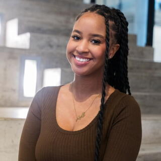 A smiling woman in a brown shirt