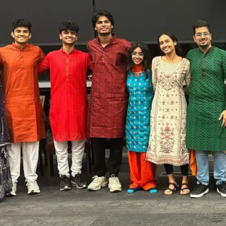A group of smiling people in traditional clothing stand together