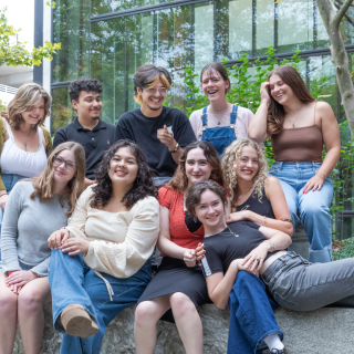 A group of smiling and laughing people sit outside together