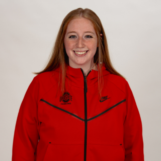 A smiling woman in a red Ohio State jacket