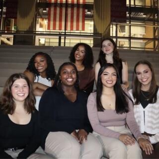 A group of people sit smiling on a set of stairs