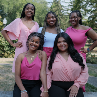A group of smiling women in pink