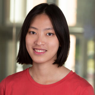 A smiling woman with short hair in a red shirt