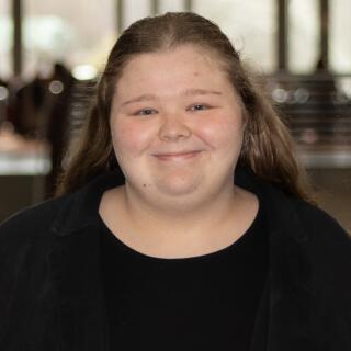 A smiling woman in a black shirt