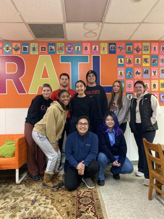 9 college students standing in front of RATL mural