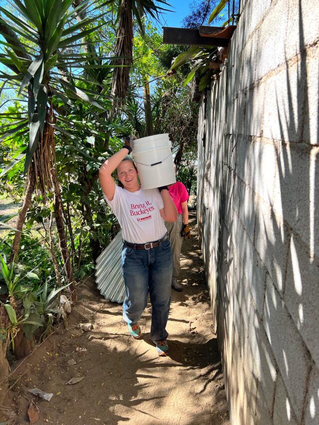 Buck-I-SERV volunteer carrying bucket of concrete at construction site