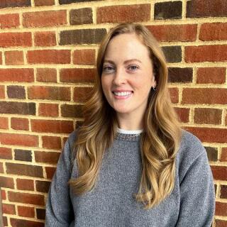 photo of a woman smiling wearing a grey sweater