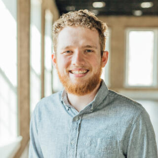 smiling man with curly blonde hair and a beard