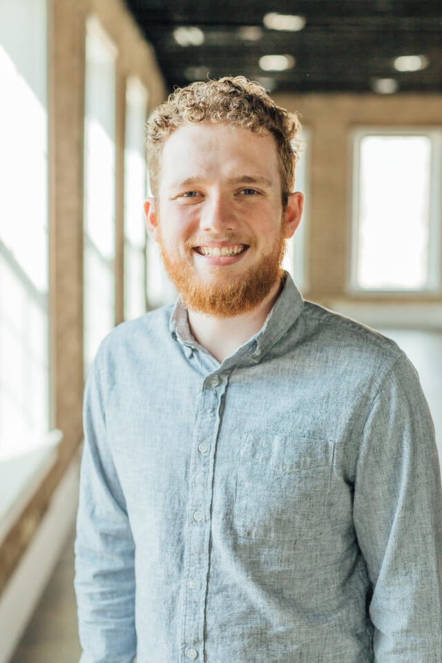 smiling man with curly blonde hair and a beard