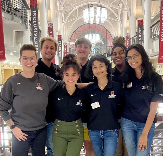 photo of seven smiling people wearing black polos