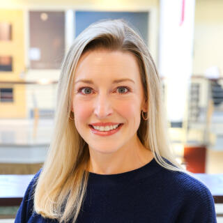 photo of smiling white woman with blonde hair wearing a blue sweater