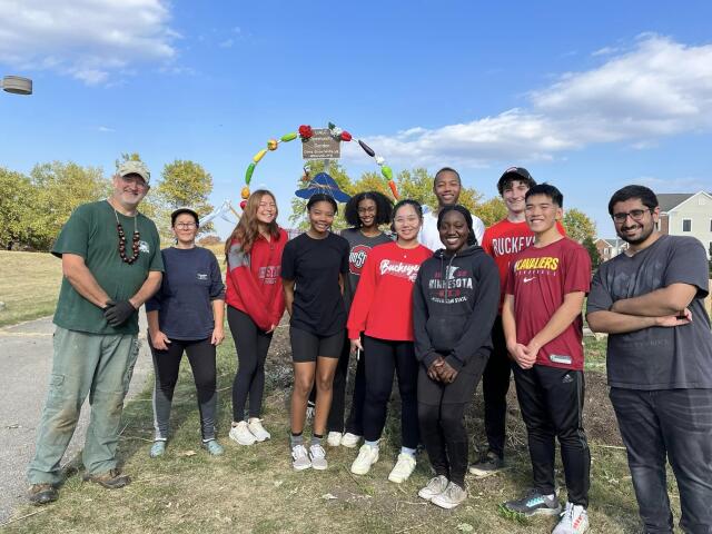 Group of college student volunteers standing together outside at community garden