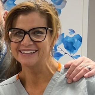 Regina smiling in OR scrubs at camera.