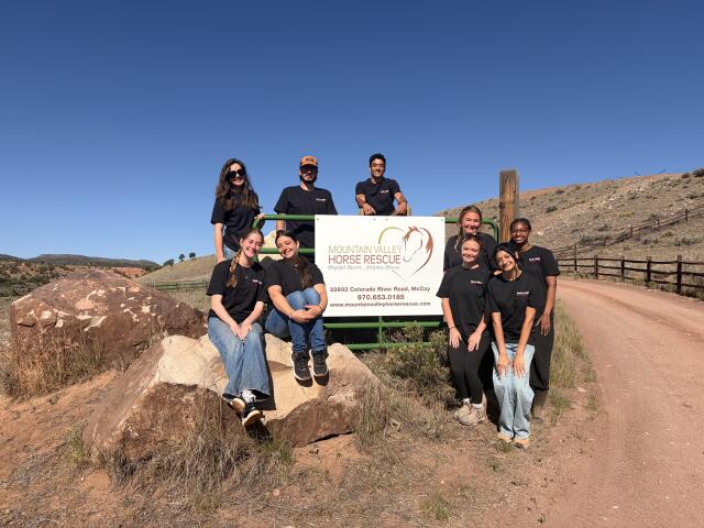 Students gather in front of Mountain Valley Horse Rescue Sign for a picture