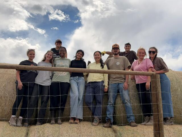 Students stand on bales of hay for a picture at Mountain Valley Horse Rescue