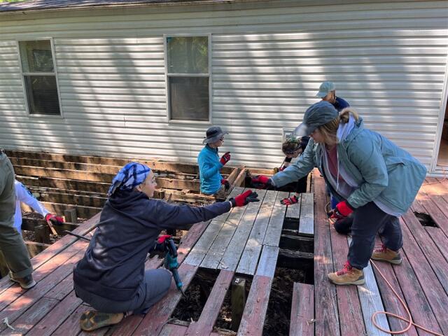 Two college student volunteers work on deck construction project