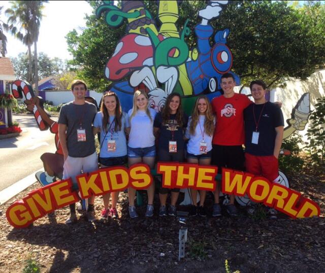 Group of college student volunteers posing with Give Kids the World sign