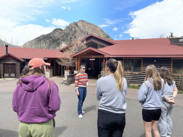 5 college student volunteers in front of camp building entrance