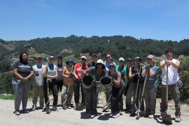Buck-I-SERV Participants pose with buckets and shovels while volunteering with Hug it Forward