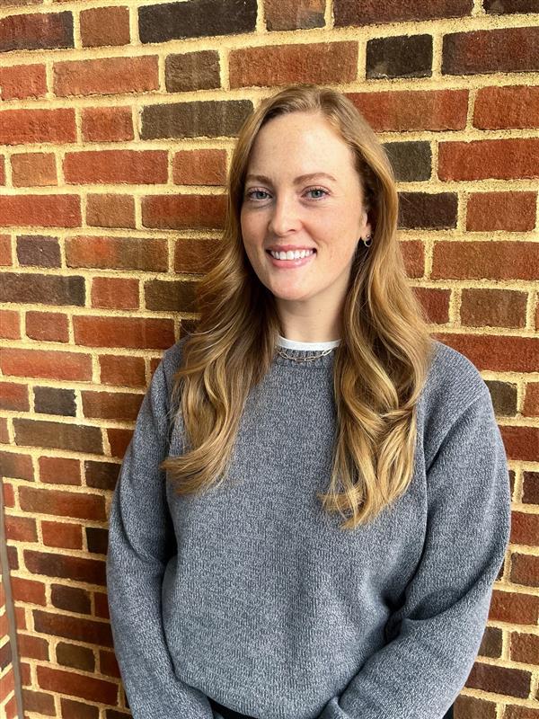 photo of a woman smiling wearing a grey sweater
