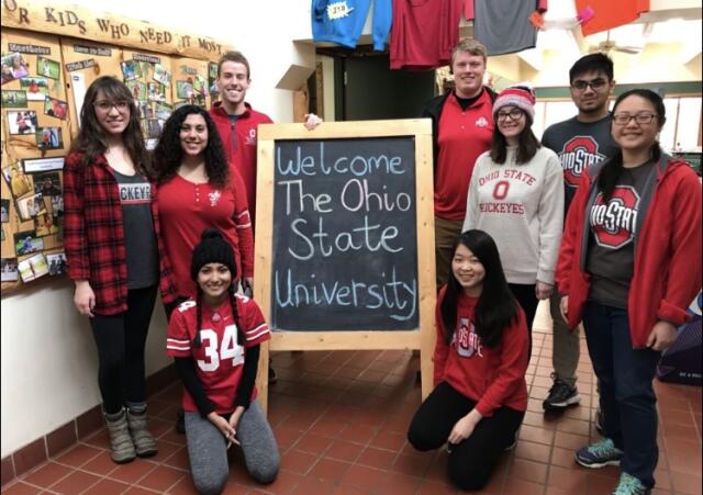 Group of Buck-I-SERV alternative break participants gathered around welcome sign at One Heartland