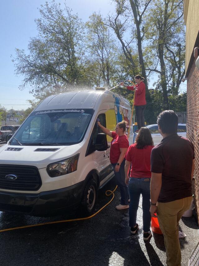 Four volunteers work to clean the Humane Association's van.