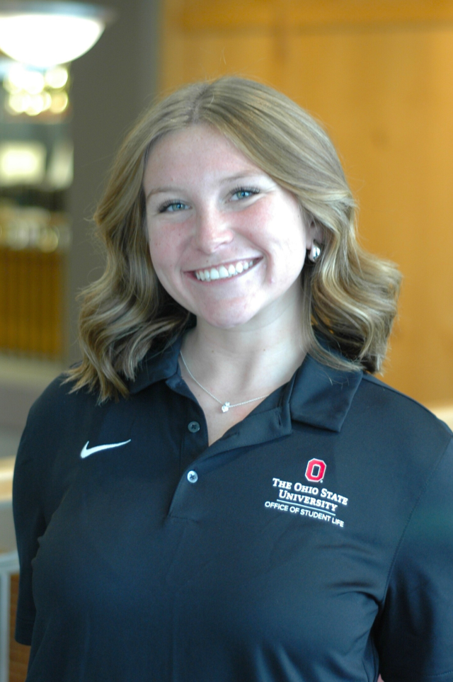 A woman in a black polo smiles