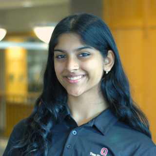 A woman in a black polo smiles