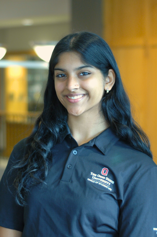 A woman in a black polo smiles