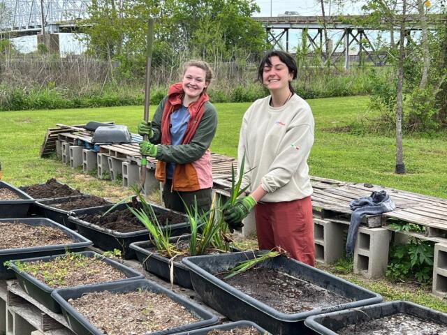 Two college student volunteers working with soil and plants outside during Buck-I-SERV trip