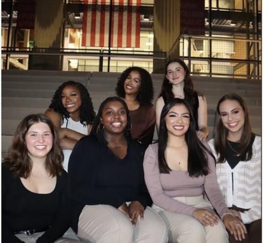 A group of people sit smiling on a set of stairs