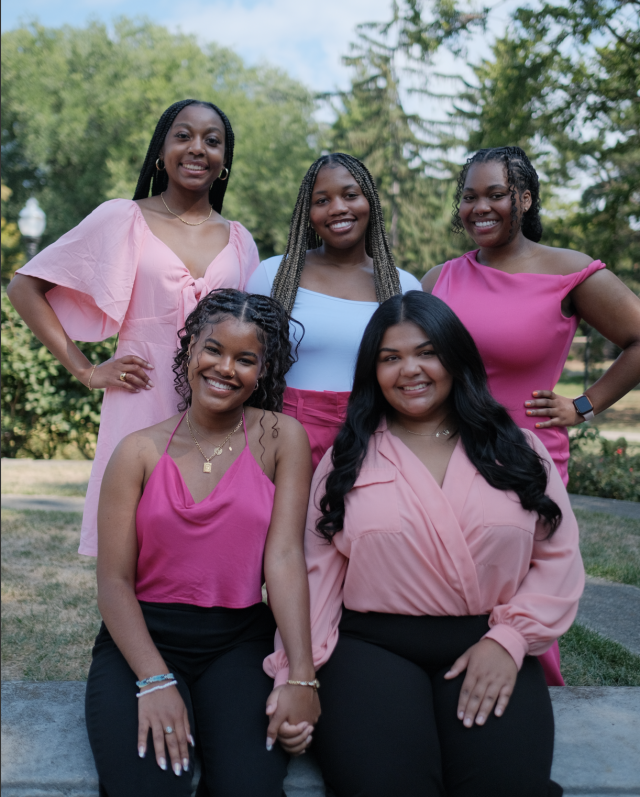 A group of smiling women in pink