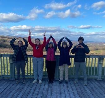 Group of 5 college student volunteers posing outside on deck at Natural Tunnel State park