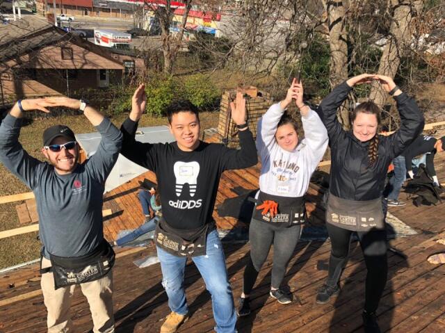 Four college students spelling O-H-I-O on top of a roof