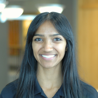 A woman in a black polo smiles