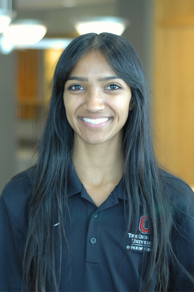 A woman in a black polo smiles