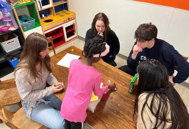 Four Buck-I-SERV students working with a young student at Solomon's Temple