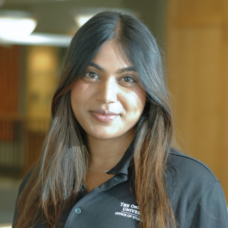 A woman in a black polo smiles