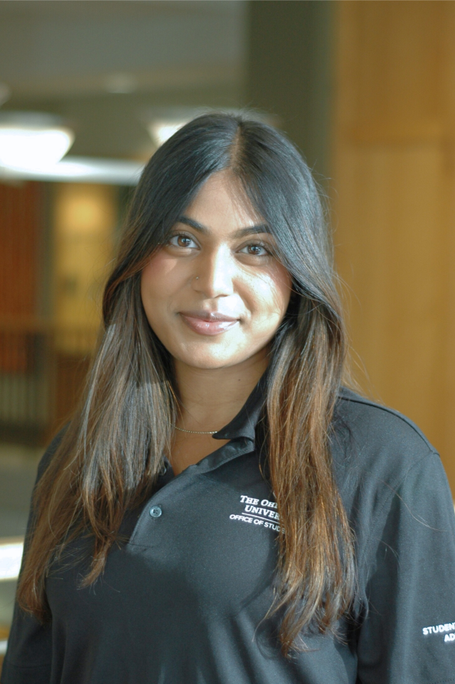 A woman in a black polo smiles