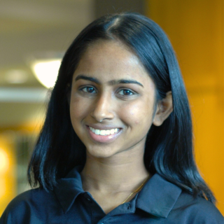 A woman in a black polo smiles