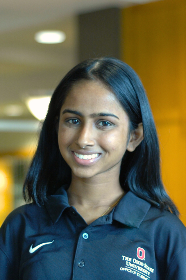 A woman in a black polo smiles